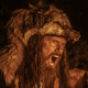 man wearing bear skin screaming.
